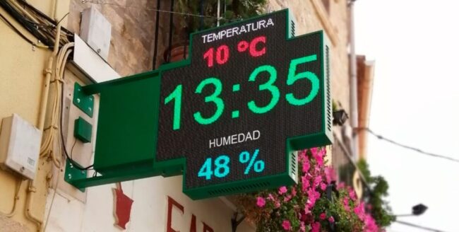 como-captar-mas-clientes-farmacia Fachada de una farmacia con una cruz LED visible para atraer la atención de los peatones.