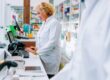 Farmacéutica haciendo cobros en una farmacia atenta para evitar descuadres en el cierre de caja