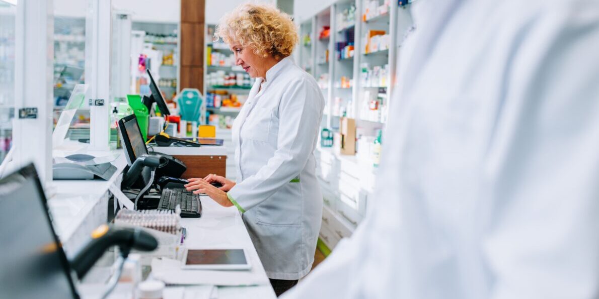 descuadres-caja-farmacia Farmacéutica haciendo cobros en una farmacia atenta para evitar descuadres en el cierre de caja
