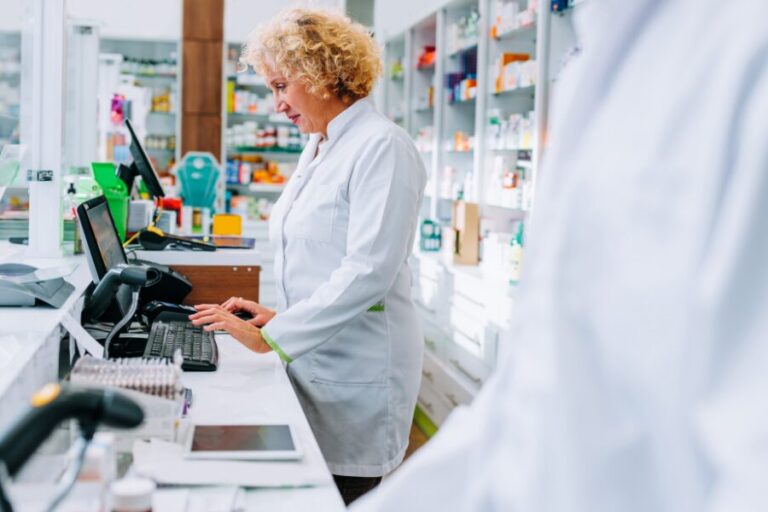 Farmacéutica haciendo cobros en una farmacia atenta para evitar descuadres en el cierre de caja